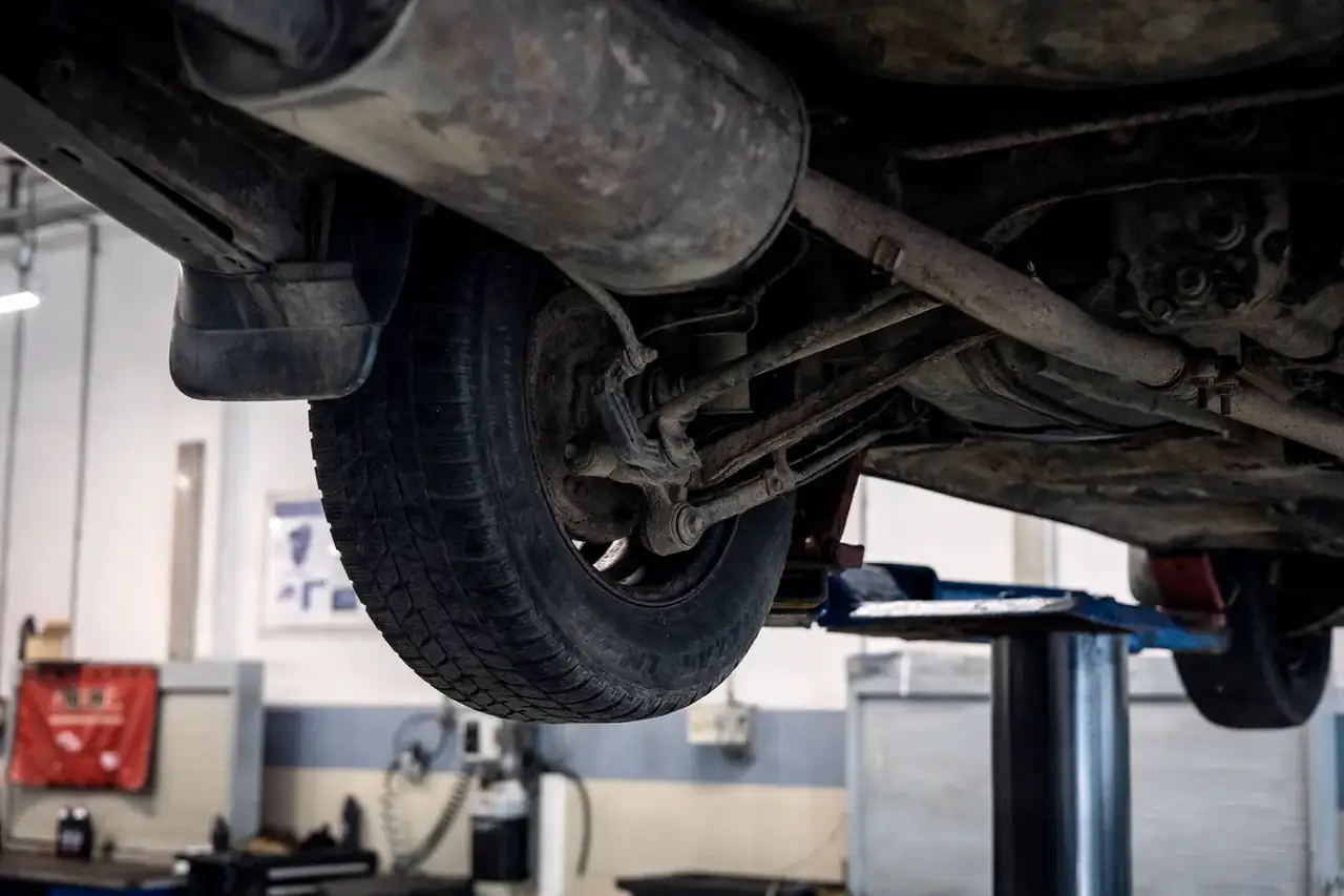 Onderzijde van een geheven auto: ophanging en uitlaat in het zicht